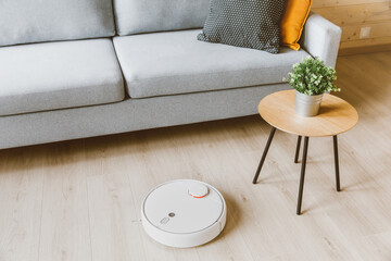 Wireless Robotic vacuum cleaner  cleaning a wooden floor in living room