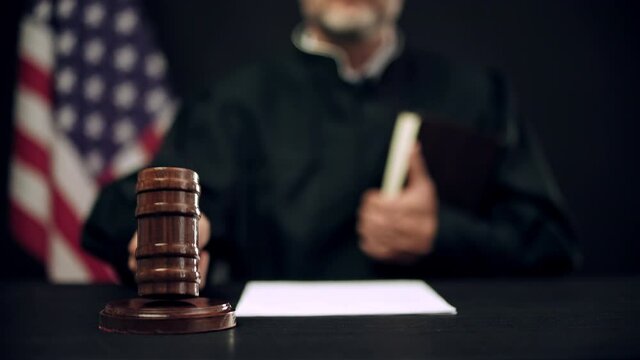 Male judge hitting gavel three times, calling to stand court members, us justice