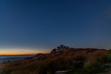 Rock formations at Stowe's Hill, Cornwall in silhouette against the sky as the light fades