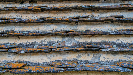 Close up of rocky wall with small oblong stones, texture concept