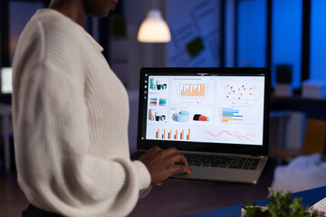 African american entrepreneur woman analyzing financial graphs typing company annual reports...