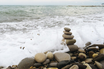 A balancing pyramid of rocks on the beach during a storm