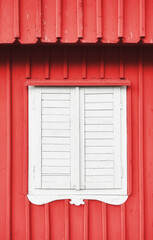 White wooden shutter on a red wall.