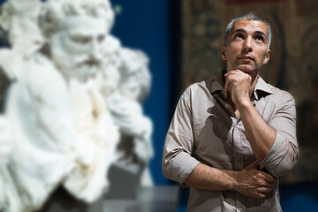 Man is looking at the exposition in the museum.