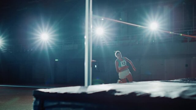 High Jump Championship: Professional Female Athlete Running and Successfully Jumping over Bar. Determination, Motivation, Effort of a True Champion. Cinematic Light, Dolly Slow Motion Shot