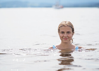 Young girl swims in the lake