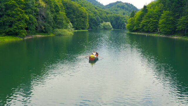 Young couple in a boat on the Biogradsko Lake in Montenegro. Aerial view 4K.
