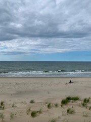 Lonely human silhouette at the wild empty beach, sea view background
