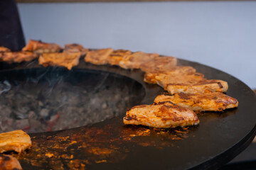 Process of cooking fresh juicy meat steaks on brazier at summer local food market - close up view. Outdoor cooking, gastronomy, cookery, street food concept