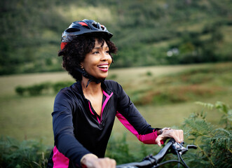Cheerful female cyclist enjoying a bike ride - obrazy, fototapety, plakaty