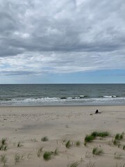 Fototapeta na wymiar Lonely human silhouette at the wild empty beach, sea view background