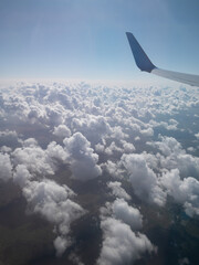 Naklejka na ściany i meble Fluffy clouds in the heaven, view from the aircraft 