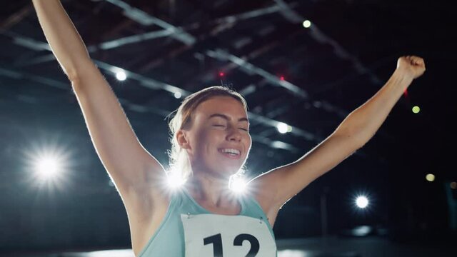 Portrait of Professional Female Athlete Happily Celebrating New Record on a Sport Championship. Determined Successful Sportswoman Raising Arms after Winning Gold Medal. Static Medium Shot