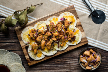Overview of homemade taco-pizza with chicken, cheese and onion with low key composition