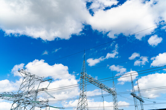 View of huge electric supply. Big electricity construction at the blue cloudy sky background. Low angle view. Stock photo