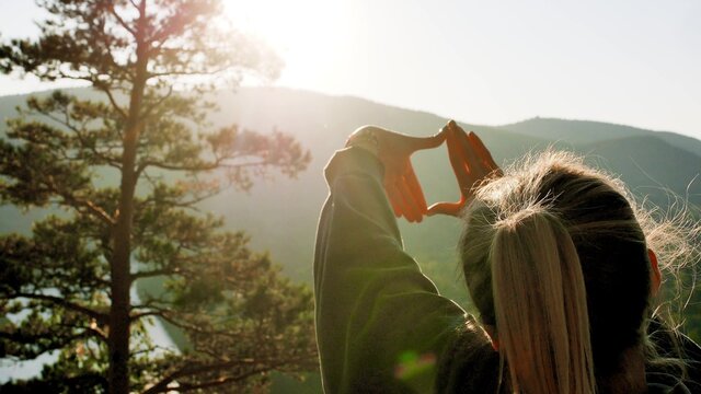 A Woman Traveler Stands On The Top Of A Mountain Near The Banks Of The Mana River In Siberia And Enjoys A Beautiful View.