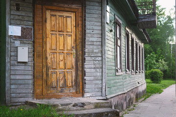 Wooden door on old dull wooden plank building corner