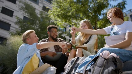 Group of students sitting on staircase, celebrating together.
