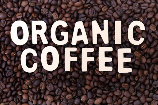 Organic coffee word on roasted coffee beans background. Concept for cafe ,coffee shop and drinking coffee beverage .