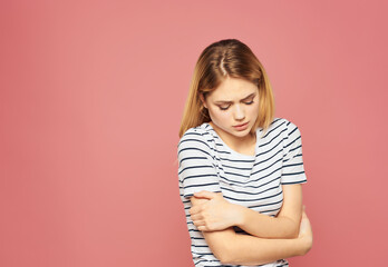 Obraz premium blonde woman in a striped T-shirt discontent upset studio pink background