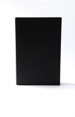 A black, blank hardcover book on white background with copy space.