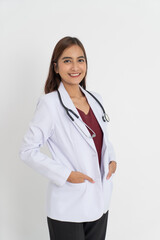 female doctor standing sideways looking at the camera with good mood smiling teeth with hands in pocket