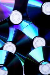 Closeup detail of multiple CD and DVD discs, software, music and film format.