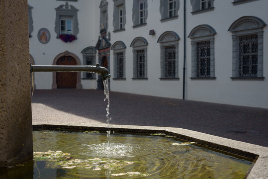 Fountain beside the roman catholic church of the Sacred Heart or Herz-Jesu-Basilika on Stiftsplatz, Tyrol, Hall in Tirol, Austria