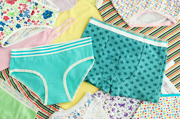 Children's underwear folded as a background. Panties and T-shirts for a boy's girl. Lots of baby underwear in one pile. Clothes for the child. - obrazy, fototapety, plakaty