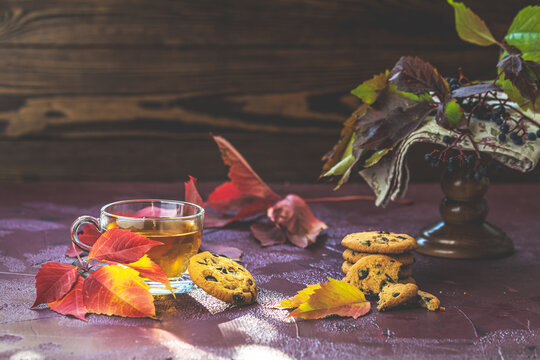 Autumn teatime composition on dark background with colored leave