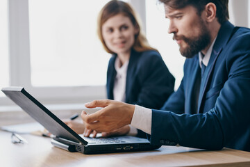  colleagues sitting at a desk with a laptop communication officials