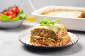 Lasagna - Lasagne alla bolognese with spinach in the dough, ragu - meat sauce, bechamel and parmesan cheese. Italian food.  Horizontal image.