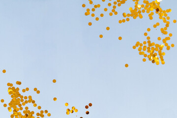 Light blue background with golden confetti, selective focus