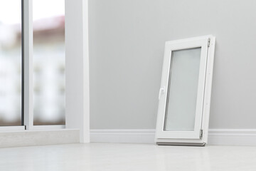 Modern single casement window near light grey wall indoors, space for text