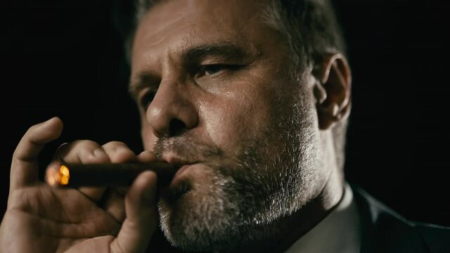 Relaxed middle-aged man smoking cigar, bad habits, harm of smoke, addiction