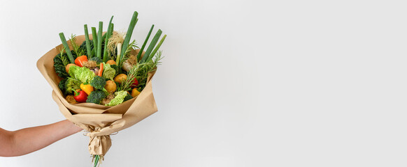 Close-up image of woman holding bouquet made of organic home grown vegetables.
