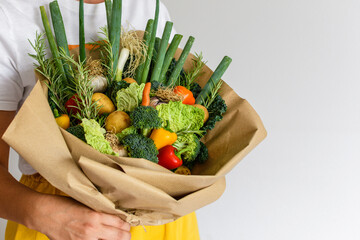 Close-up image of woman holding bouquet made of organic home grown vegetables.