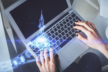 Double exposure of woman hands working on computer and creative hologram drawing. Top View. Start up concept.