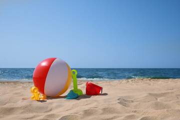 Obraz premium Many different sand toys and beach ball near sea, space for text