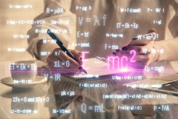 Double exposure of formulas sketch hologram and woman holding and using a mobile device. Education concept.