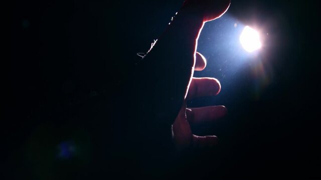 Man pulling his hand towards the light 