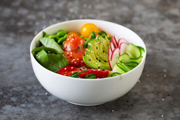 Plate with avocado, salmon, tomato and quinoa poke