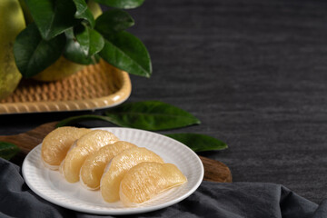 Fresh pomelo fruit on black slate background.