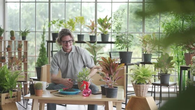man enjoys caring for his plants, watering, spraying, and decorating the plants. It is a hobby of gardening at home happily During the COVID 19 epidemic