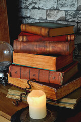 Halloween decoration in Detail. Old magic books. House of Witches. House of magic. Still life with old books, crystal ball and candle.