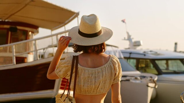 Pretty girl in hat looking at ships. Split, Croatia