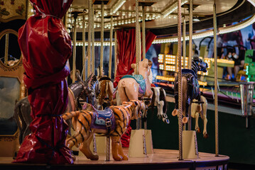 Detalle de caballos y un tigre en un carrusel vinitage en un recinto ferial. Diversión en la feria, parque de atracciones
