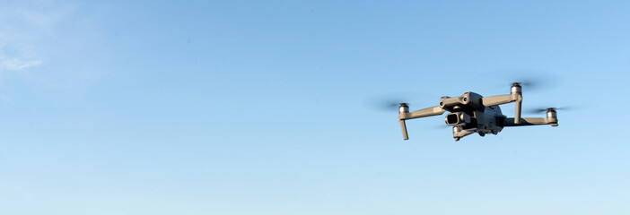 flying a quadrocopter helicopter drone in the air, in a clear blue sky, morning fog and mountains...