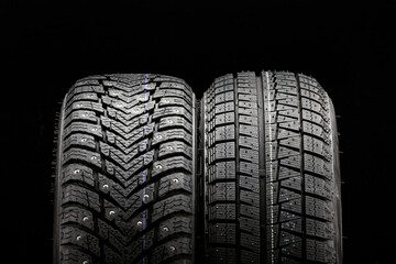 winter tires wheels are new black background. friction velcro wheel and studded tire next to two pieces © Vladimir Razgulyaev