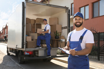 Moving service workers outdoors, unloading boxes and checking list